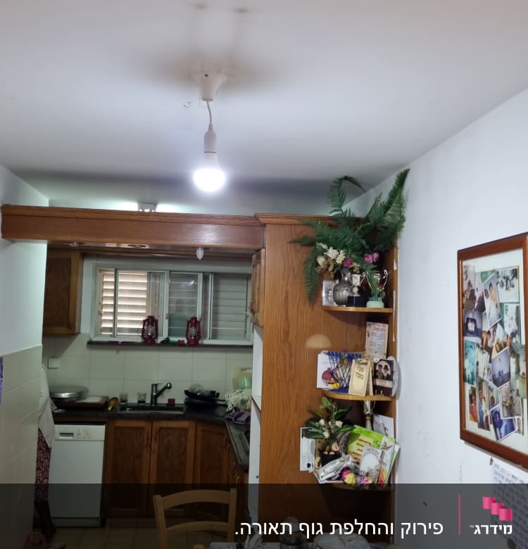 נורה תלויה מהתקרה במטבח עם שולחן אוכל